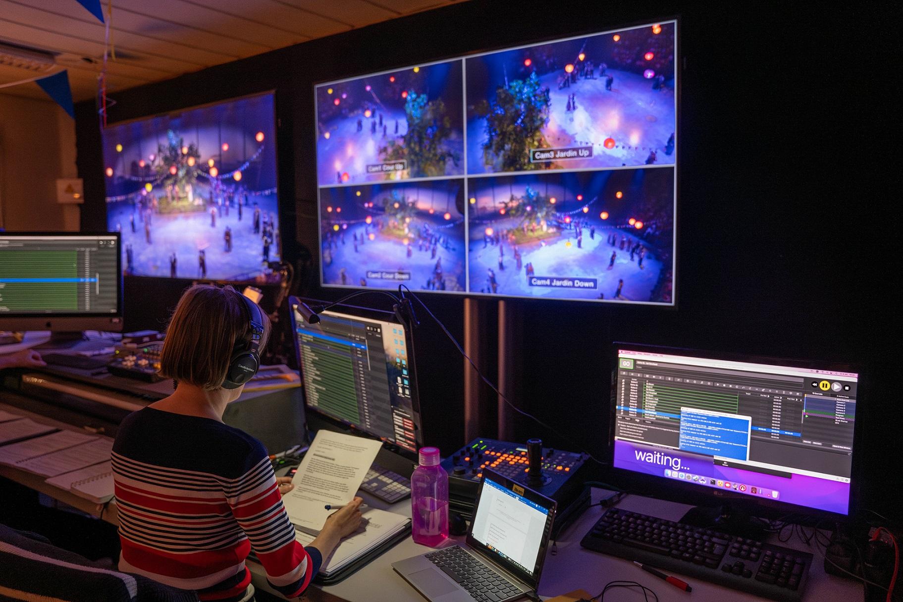 Audiobeschrijver Susanne Verberk volgt de voorstelling op grote schermen in de technische ruimte. Tussendoor leest ze live haar beschrijvingen in.