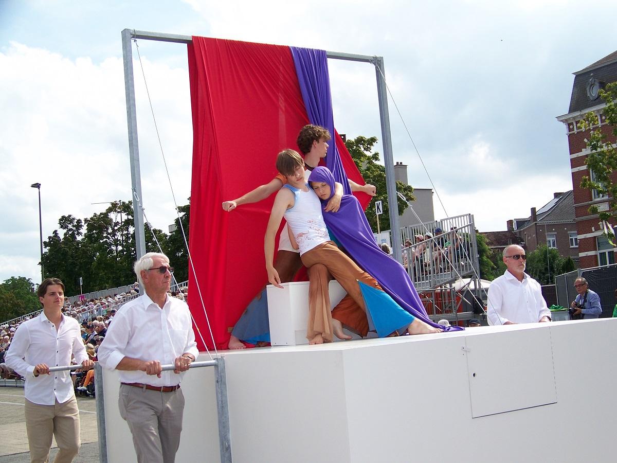 De praalwagen tijdens de Virga Jesse-ommegang met het tableau vivant. De dansers zijn verstild in een pose waarbij een van hen zich in een paarse doek heeft gewikkeld.