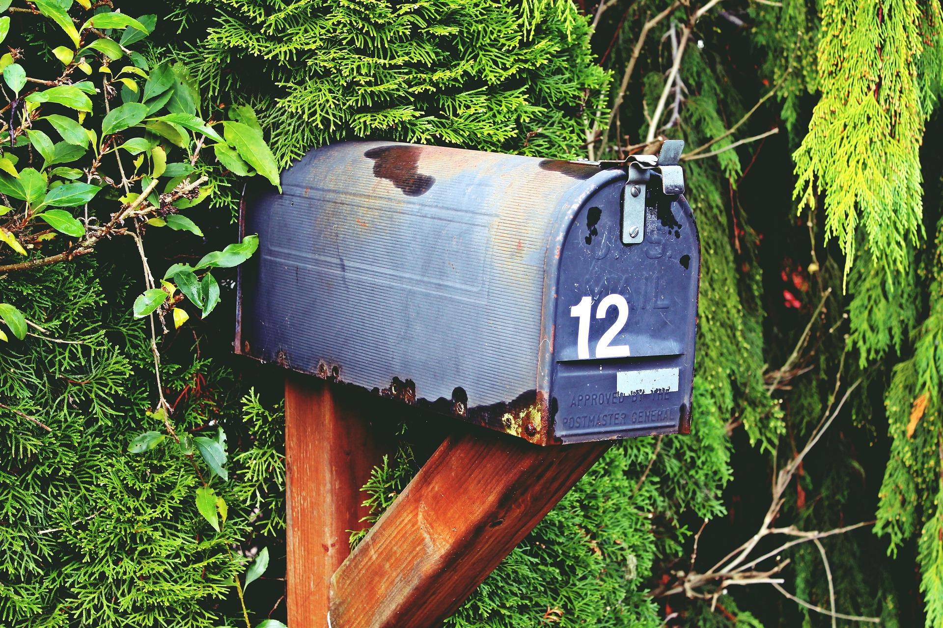 Een ouderwetse blauwe, Amerikaanse brievenbus met huisnummer 12.